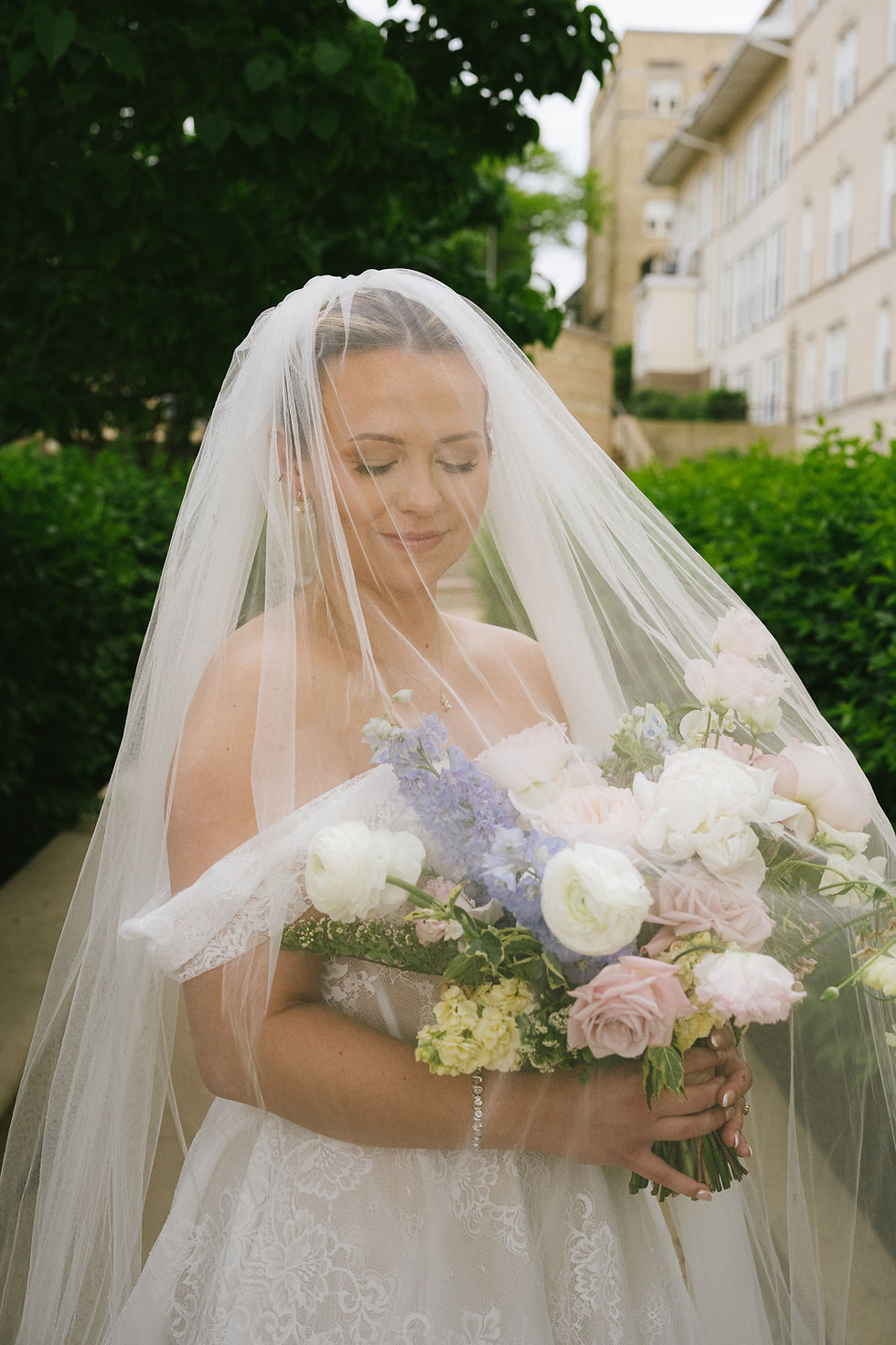 Bride under white veil with bouquet for a wedding planned by Indigo Moon Events in Madison WI