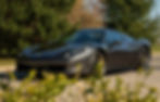 ferrari noire sur route de campagne ensoleillée