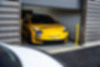 voiture jaune avec covering de la marque dinoco à la sortie du garage