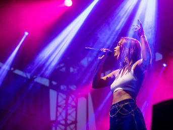 Singer performing under purple and pink moving-light beams