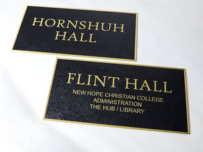 Custom embossed metal plaques with raised brass lettering
