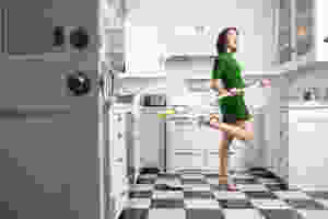 What does it mean to green clean - woman in a clean kitchen happy