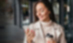 Woman looking at her personal finance AI app with a coffee in hand