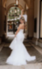 Braut im Hochzeitskleid vor einem Geschäft in der Innenstadt