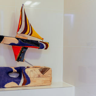 ספינה צבעונית מעוצבת על מדף לבן עם עיצוב, תכנון בשילוב ריהוט יחודי. michal-avimor