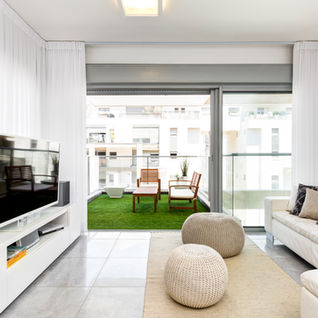 סלון מודרני לבן עם טלוויזיה גדולה, מרפסת ירוקה, ריהוט מיכל אבימור