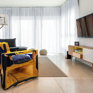 סלון מעוצב עם ריהוט צבעוני, טלוויזיה, ווילונות לבנים, תכנון בשילוב ריהוט יחודי michal-avimor