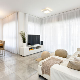סלון מודרני לבן עם טלוויזיה, חלונות גדולים וריהוט נוח. שדרוג יוקרתי, michal-avimor