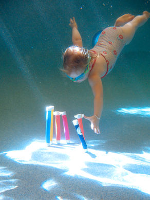 babies swimming underwater in pool 