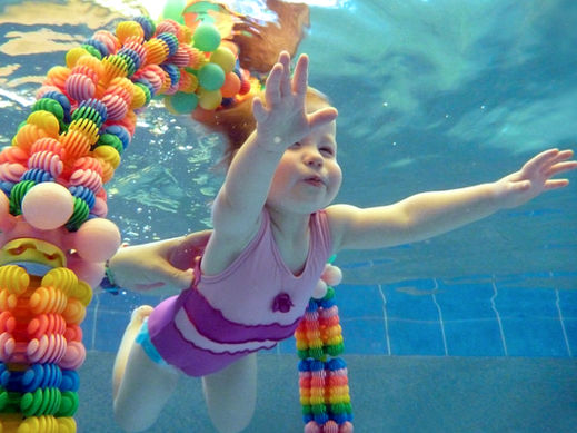 babies swimming underwater in pool 
