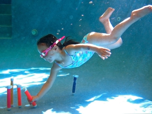 babies swimming underwater in pool 