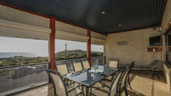 balcony with outdoor dinning table and view of the ocean