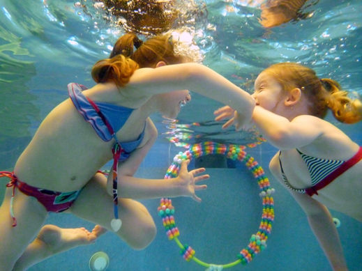 babies swimming underwater in pool 