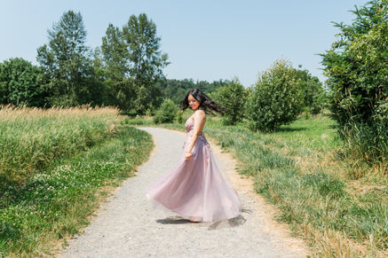 Girl in prom dress twirling and looking at her dress