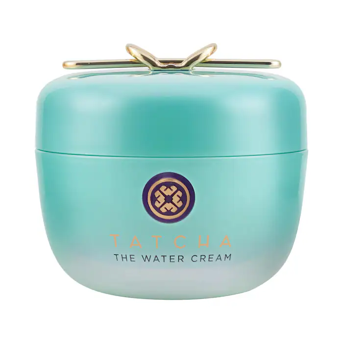 Turquoise jar of Tatcha The Water Cream with a gold emblem and shiny lid. The design is sleek and modern against a white background.