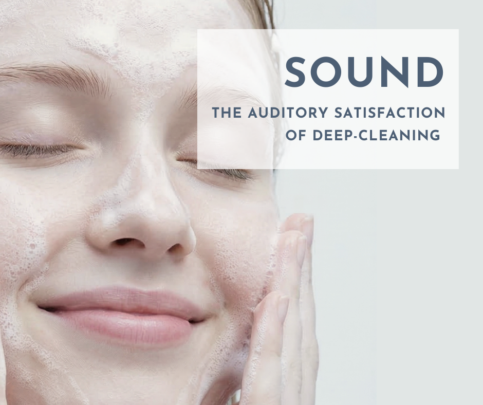 A close-up of a person's face with their eyes gently closed, smiling peacefully, covered in a fine layer of bubbling foam cleanser. Text overlay reads "SOUND THE AUDITORY SATISFACTION OF DEEP-CLEANING #AuditorySensorySkincare #BubbleASMRCleansing #DeepPoreCleanser #MoisturizingWash #SensoryEfficacyConfirmation