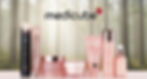Medicube skincare products in pink bottles and jars beside a black device, displayed on a table against a soft forest backdrop.