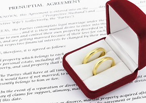 prenuptial agreement with two wedding rings insidea red box 