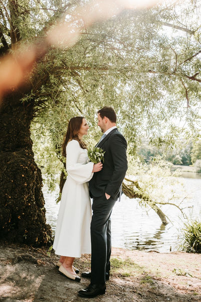 Bride wearing sun glasses and groom posing in Ørstedsparken in Copenhagen