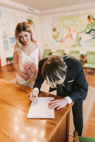 Groom signing wedding papers in Frederiksberg in Copenhagen during wedding ceremony