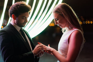 Bride and groom sharing a kiss under the vibrant lights during their Light Festival wedding ceremony in Copenhagen.