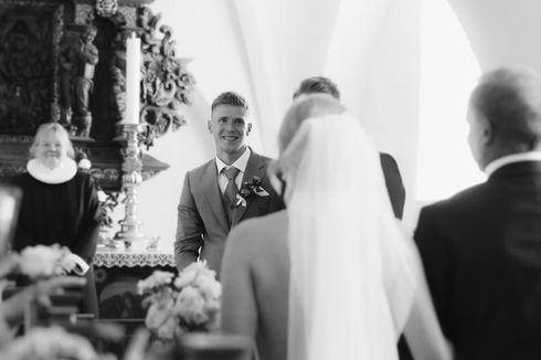 Bride and groom exchanging vows at Fårevejle Kirke in Svinninge