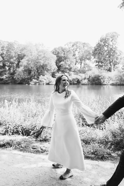 Bride wearing sun glasses and groom posing in Ørstedsparken in Copenhagen