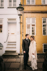 Bride and groom taking posing around brick houses in Copenhagen