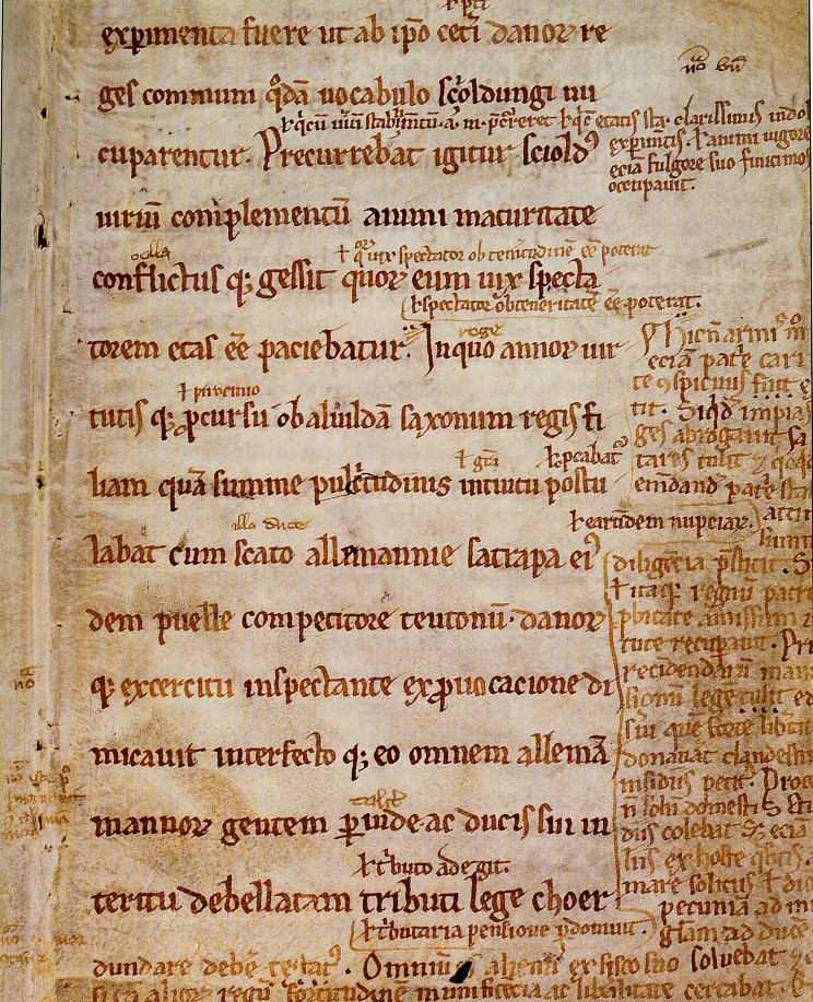 Eine Handschriftenseite der Gesta Danorum um 1200, mit kleineren Einträgen am Rand und zwischen den Zeilen, den Glossen.