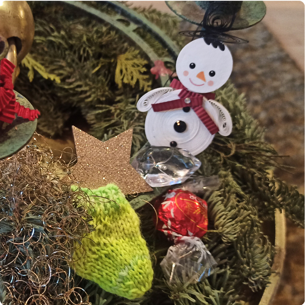 Ein Adventskranz geschmücktt mit Schneemann und einer Wichtelsocke.