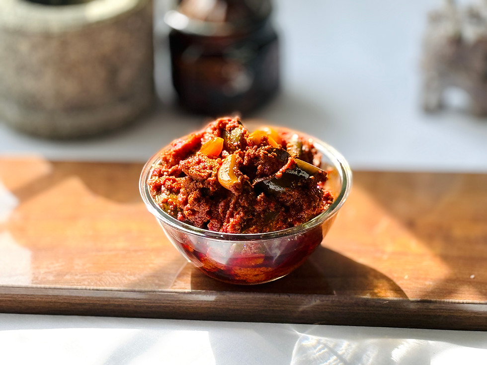 Close-up of Vellulli Avakaya showing tender garlic cloves and mango pieces.
