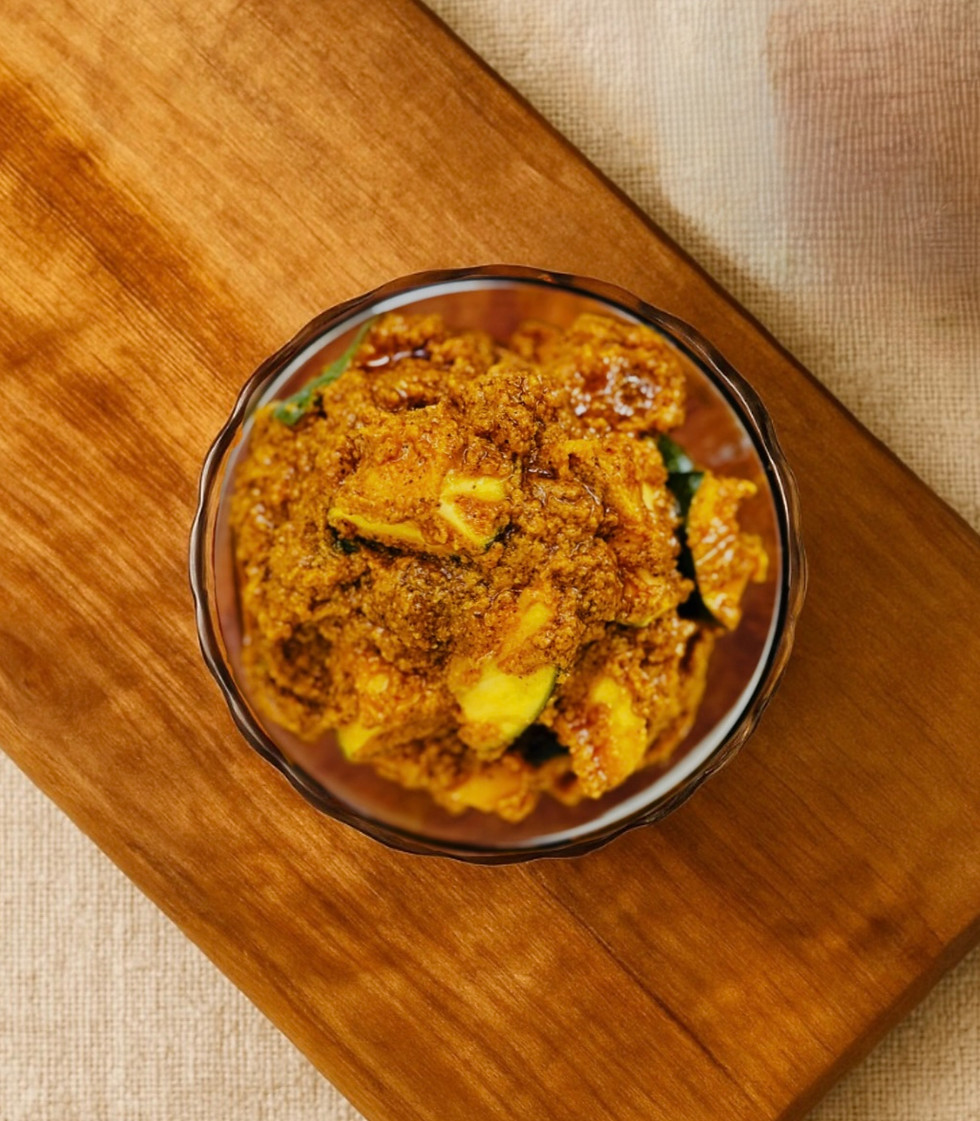 A close-up shot of green chilli and mango pieces in Pachakaram Avakaya pickle.