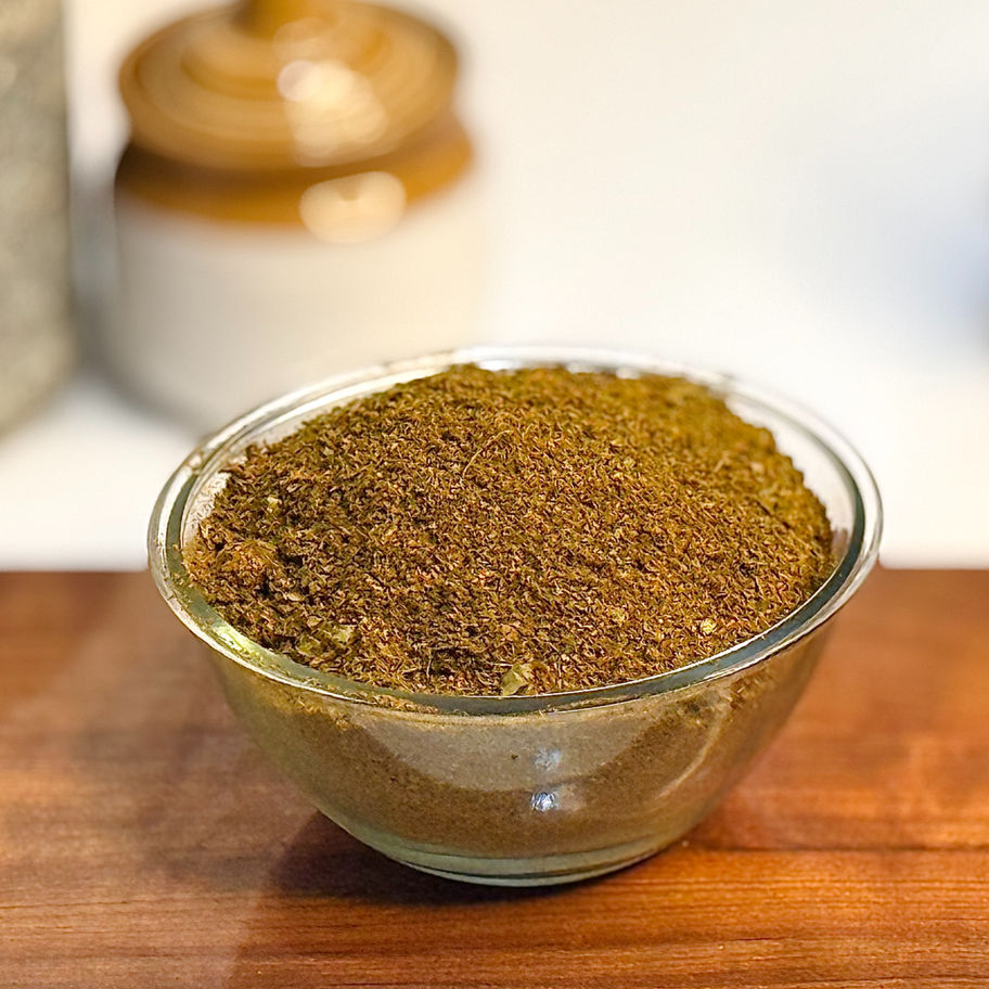 A dark green, fragrant Karvepaku Podi (Curry Leaf Powder) in a small bowl.