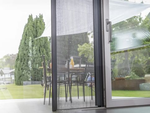 Rede mosquiteira de porta em tecido fino, impedindo a entrada de insetos.