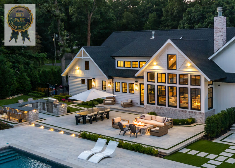 <img src=”fancy-farmhouse-house-Woodbury.jpg” alt=”Large modern farmhouse-style home at dusk with a landscaped backyard, featuring a patio with outdoor seating, fire pit, dining area, built-in grill, and a swimming pool.”/>