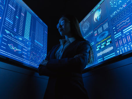 woman in tech standing before data screens