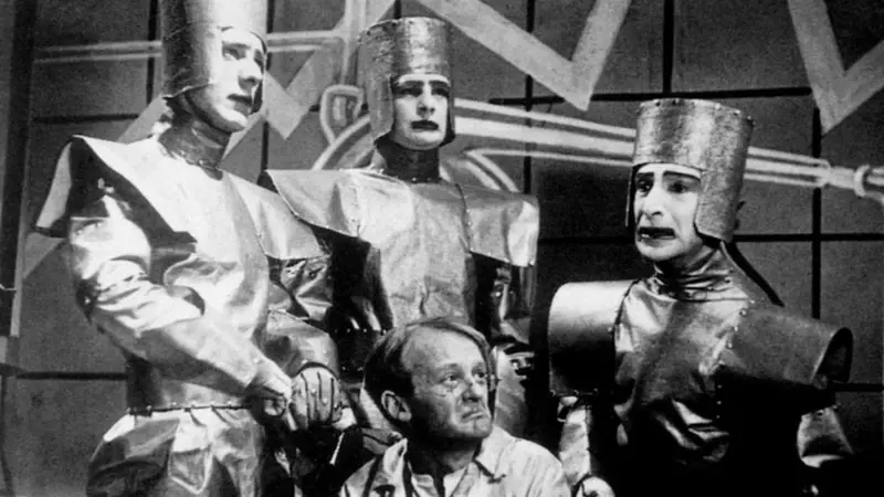 The word “robot” made its first appearance in a 1920 play by the Czech writer Karel Čapek entitled R.U.R., for Rossum’s Universal Robots. Deriving his neologism from the Czech word “robota”, meaning “drudgery” or “servitude”, Čapek used “robot” to refer to a race of artificial humans who replace human workers in a futurist dystopia. (In fact, the artificial humans in the play are more like clones than what we would consider robots, grown in vats rather than built from parts.)