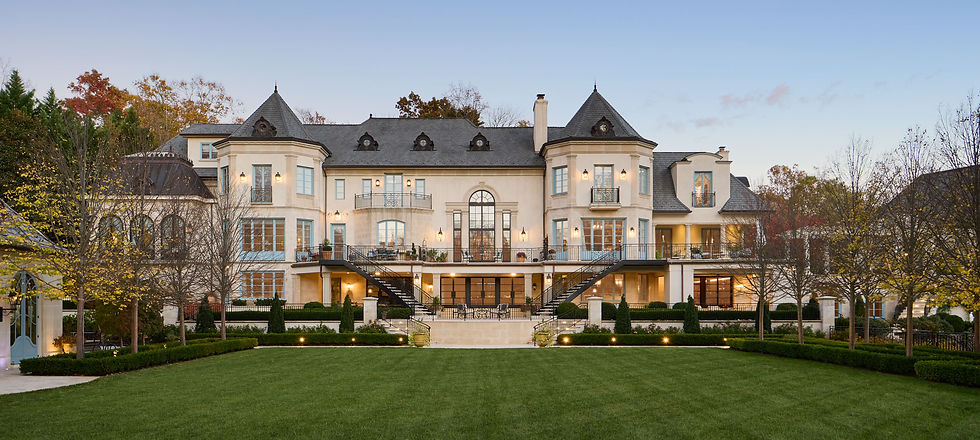 Grand luxury estate with symmetrical architecture, balconies, and manicured garden