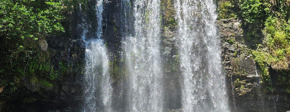Wide waterfall dropping into murky looking water