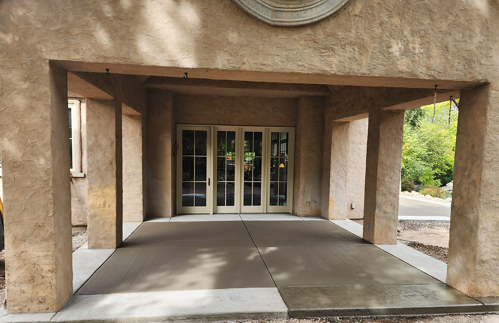 This image is a stamped concrete boarder and broom finish inside of the boarder. It is an exit covered patio which is covered by the homes roof and held up by colums