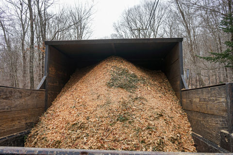 Dump truck filled with wood chips from tree removal and chipping service in Hartford County, CT.
