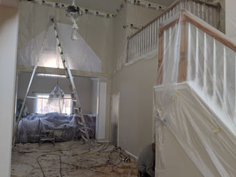 Interior painting project with walls and furniture carefully protected, demonstrating professional prep and clean finish results.