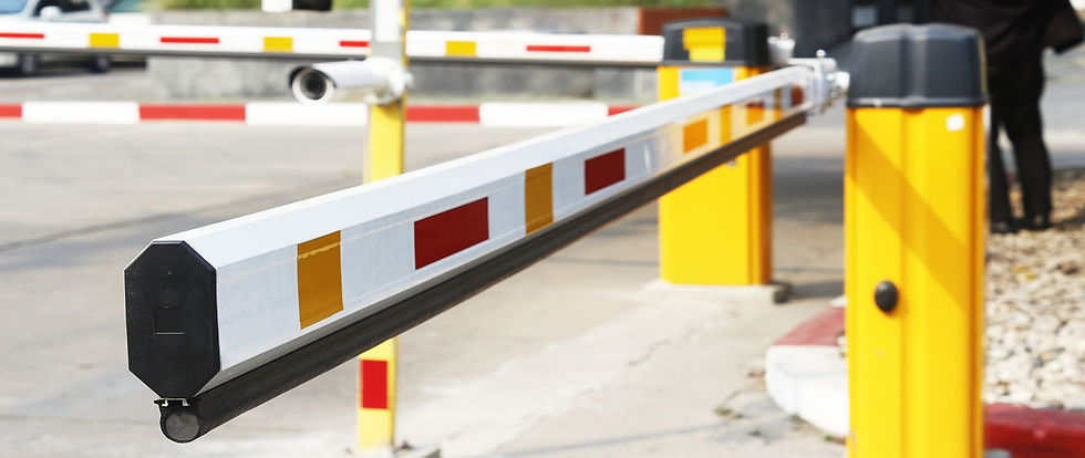 a close-up of a vehicle boom barrier with a yellow and red striped arm in an open position, installed at a secure access point.