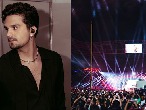 Luan Santana cantando em palco com multidão ao fundo durante show da turnê
