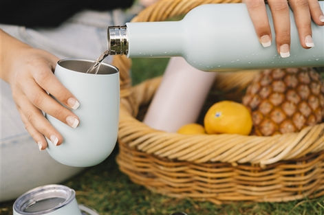 Water being poured from a double insulated water bottle into a double insulated wine tumbler from Annabel Trends.