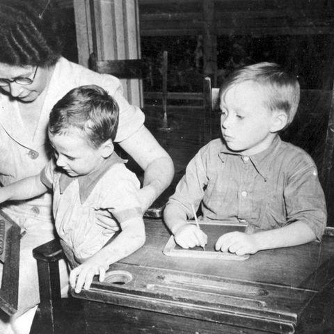 A teacher with two students and an abacus.