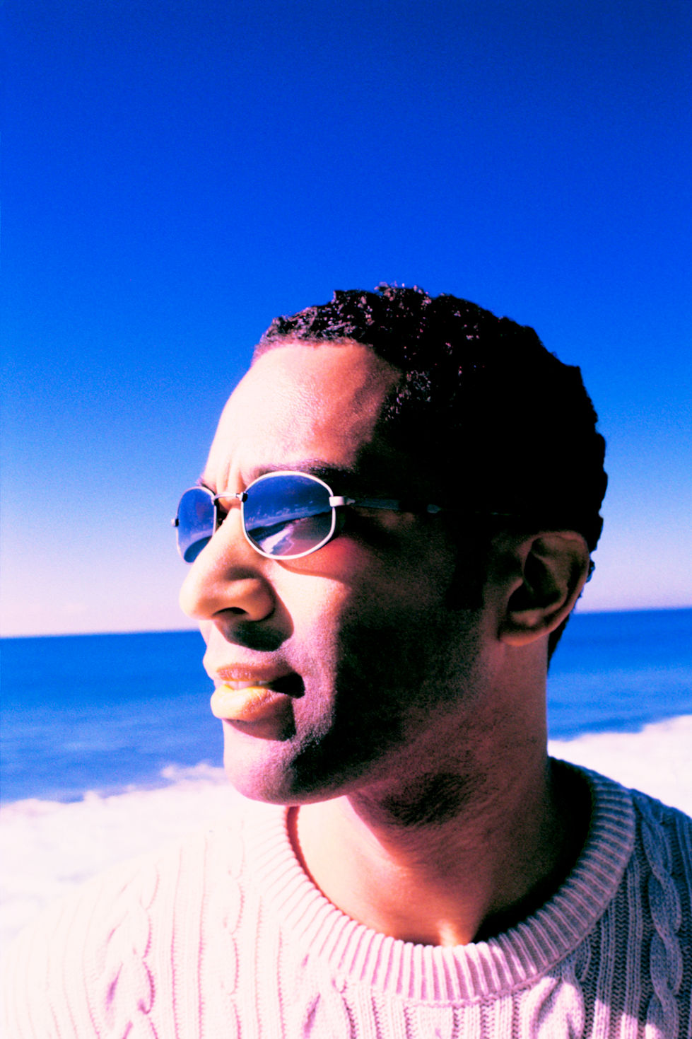 portrait-of-man-wearing-sunglasses-on-beach-with-ocean-in-background-1761002