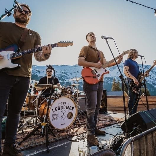 A 4-men Weymouth band playing music in front of the alps.