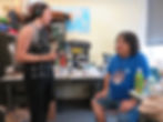 Lindsay interviewing Chris in his lab. Various specimens are on his desk.