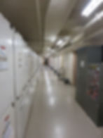 A long, hall with many cabinets.